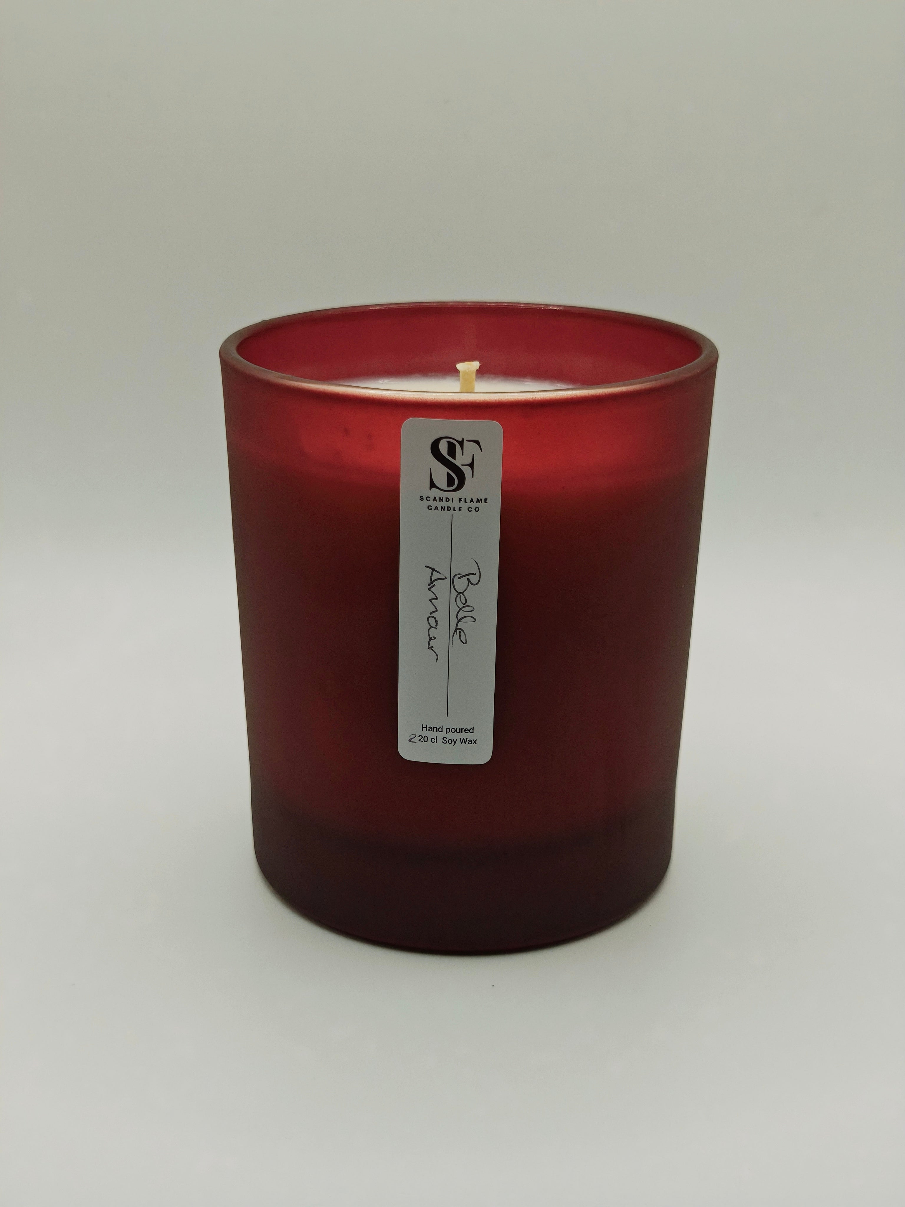 Red candle with a label 'Belle Amour' on a white background
