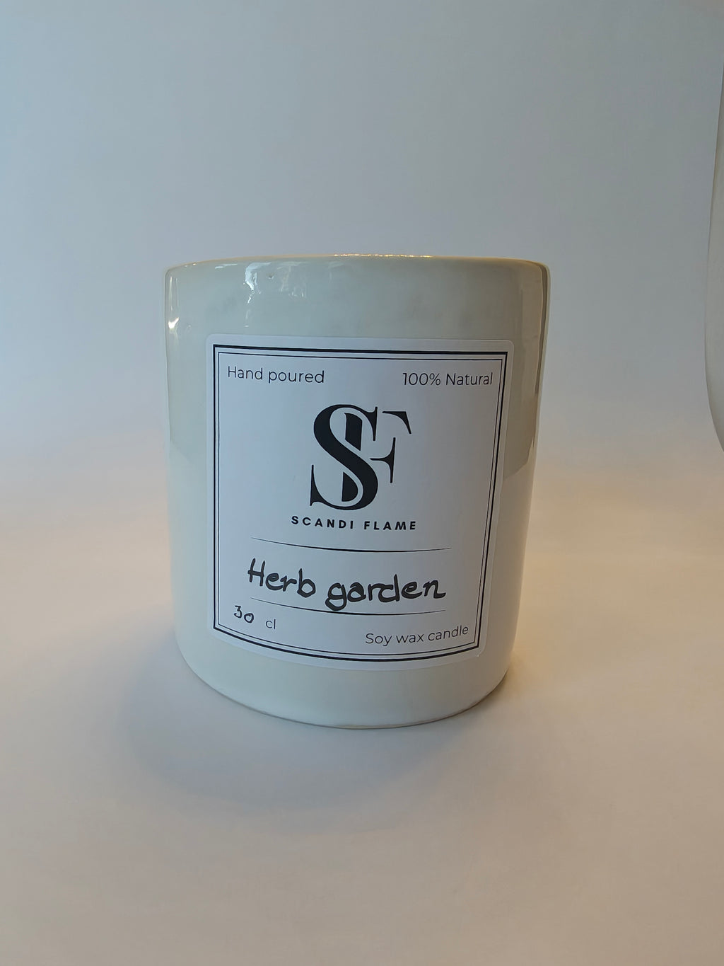 Candle labelled 'Herb Garden' by 'Srandi Flame' on a white background
